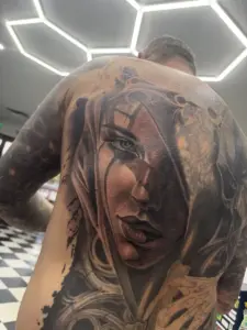 Black and grey hooded woman portrait back piece tattoo by Moose, Calgary Tattoo Company