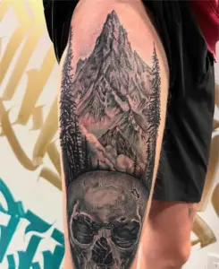 Black and grey mountain and skull tattoo by Kylie, Calgary Tattoo Company