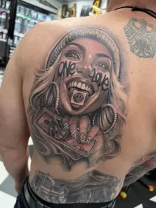 Black and grey One Love portrait back piece tattoo by Moose, Calgary Tattoo Company
