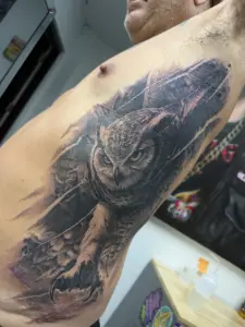 Black and grey owl rib tattoo by Moose, Calgary Tattoo Company