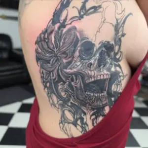 Black and grey skull and flower rib tattoo by Tonka, Calgary Tattoo Company