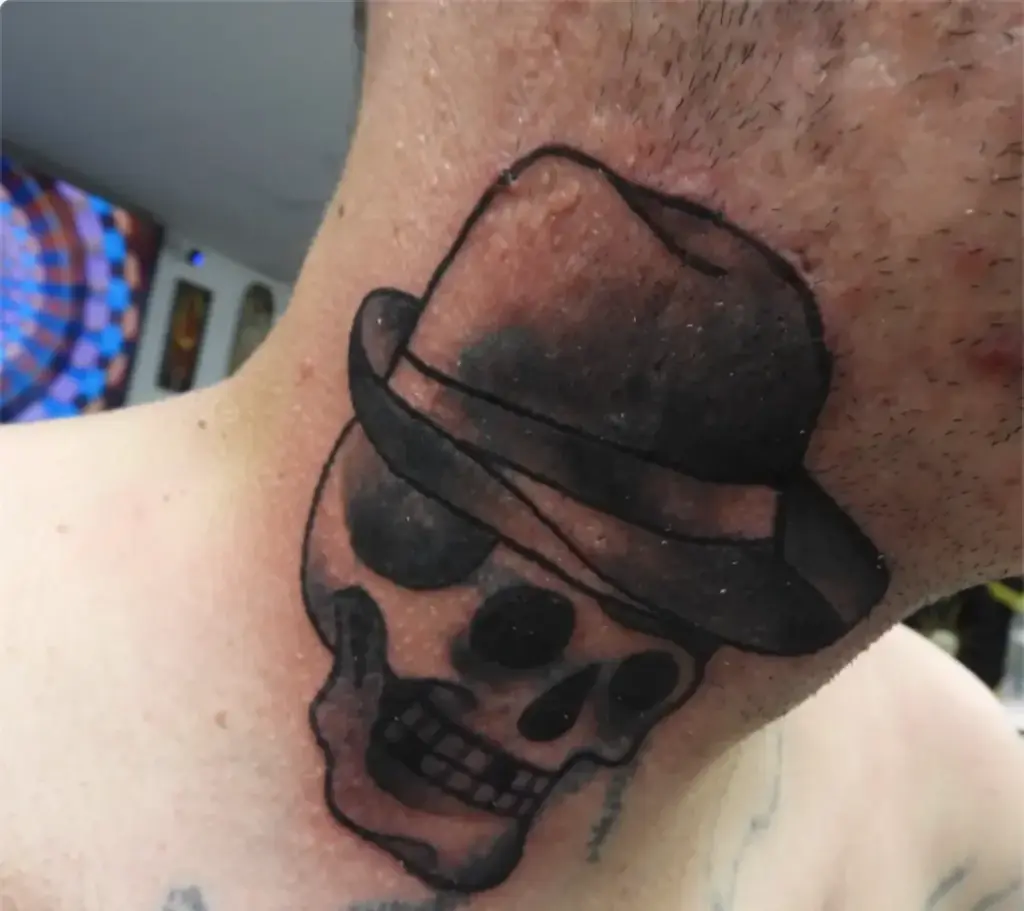 Black and grey traditional skull in a fedora tattoo by Keith, Calgary Tattoo Company