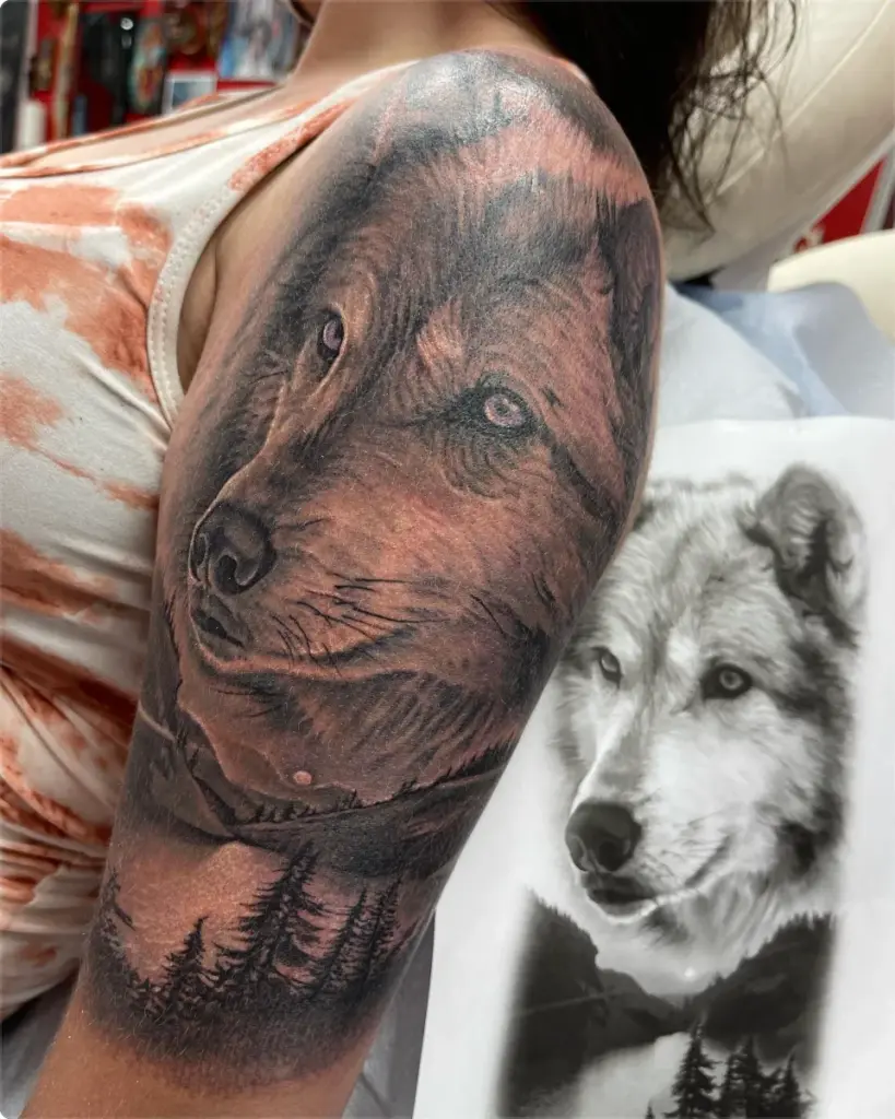 Black and grey wolf above a mountain lake tattoo by Moose, Calgary Tattoo Company