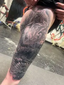 Black and grey woman by a lotus pond leg tattoo by Moose, Calgary Tattoo Company